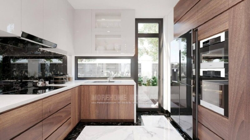 Là một trong những xu hướng thiết kế nội thất ấn tượng trong những năm tới, trang trí phòng bếp hiện đại tôn lên vẻ đẹp mộc mạc nhưng không kém phần sang trọng của gỗ điển hình là gỗ óc chó. Loại gỗ rất được ưa chuộng trong các siêu xe bởi vẻ đẹp ấn tượng từ vân, màu gỗ. Như trong ý tưởng thiết kế phòng bếp tại biệt thự Vinhomes Imperia Hải Phòng, sự hài hòa tôn lên nét đẹp giữa truyền thống và hiện đại, tủ bếp dưới gỗ óc chó và tủ bếp trên gỗ công nghiệp trắng bóng. Tủ bếp gỗ công nghiệp và tủ bếp acrylic
